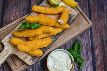  Crispy home made  deep fried   chicken strips . Breaded  with cornflakes chicken  breast fillets  with chilly peppers and fresh   basil on wooden rustic background