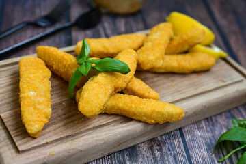  Crispy home made  deep fried   chicken strips . Breaded  with cornflakes chicken  breast fillets  with chilly peppers and fresh   basil on wooden rustic background