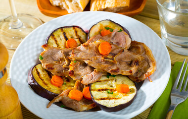 Appetizing grilled lamb chops with vegetable garnish of eggplant, carrots and greens