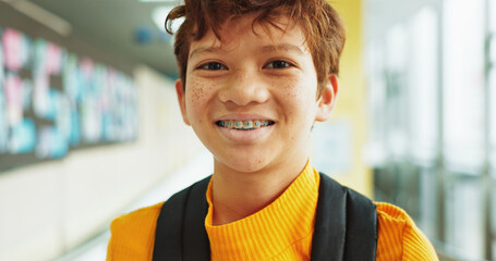 Portrait, learning and boy with braces, student and confidence with smile, knowledge and elementary academy. Face, kid and childhood with backpack, studying opportunity and campus with education © BuyOutFelix01/peopleimages.com