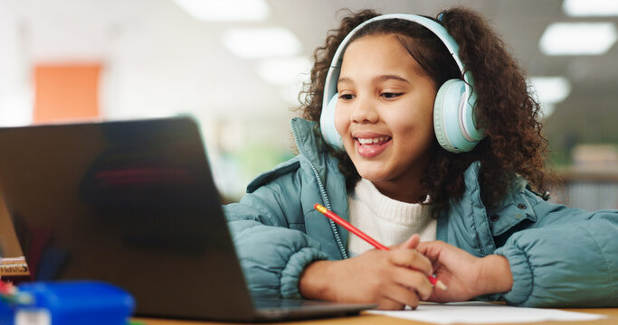 Student, girl and headphones with laptop for e learning, video call or online class for knowledge. Virtual school, development and child on technology for assignment on teaching platform in library
