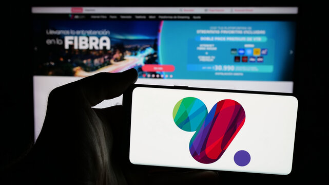 Stuttgart, Germany - 04-03-2025: Person holding mobile phone with logo of Chilean company VTR Comunicaciones SpA on screen in front of web page. Focus on phone display.