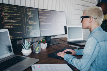 Young Woman Programming Code at Home Office Workstation in a Casual Denim Shirt Showing Focus and...