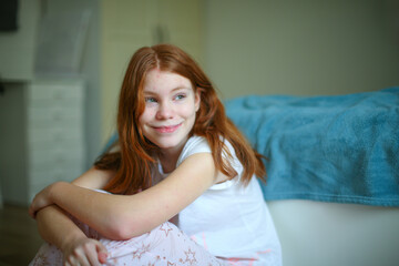 Naklejka premium Close-up of cheerful young girl with freckles and red hair, looking away with a big playful smile