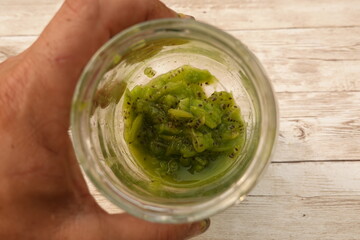 Chef holding glass jar with chopped kiwi fruit and juice