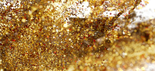 Sparkling gold and red glitter falling, festive backdrop for holidays or celebration