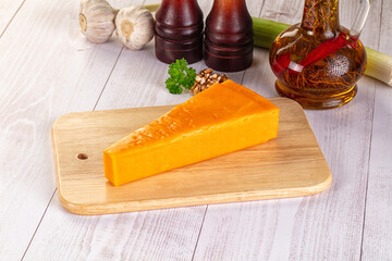 Yellow cheddae cheese over board