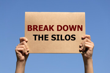 Break down the silos on brown paper holding by 2 hands of a man