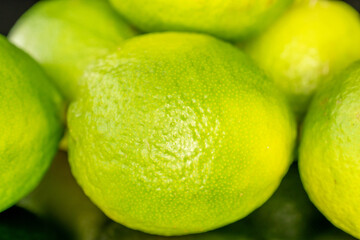 Several ripe limes, macro, isolated on black background.