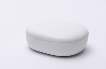 White charging case for wireless earphones on white background