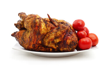 Whole grilled chicken on a plate with red tomatoes.