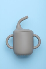 Silicone drinking bowl with a straw for baby on a blue background