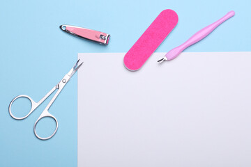 Nail care tools, manicure set with white blank paper sheet on blue background. Space for your text...