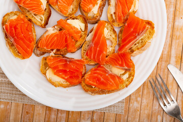 Delicious sandwiches with bread, smoked salmon and butter on a table in a cafe