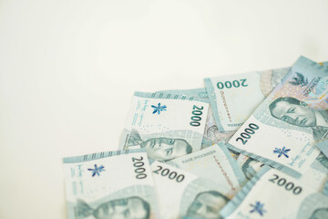 A stack of two thousand rupiah banknotes with negative space, Indonesian money. suitable for background, finance, banking, cash, savings.