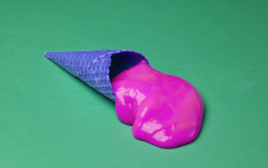 Waffle cone with purple slime on green background. Minimal halloween layout