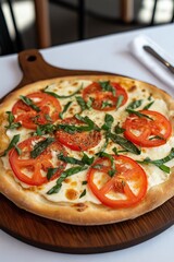 A pizza with tomatoes and basil on top. The pizza is on a wooden board. The pizza is topped with cheese and tomatoes