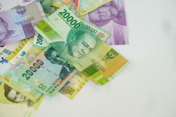 stack of various Indonesian banknotes with negative space, from one thousand rupiah to twenty thousand rupiah. Suitable for background, finance, banking, cash, savings.