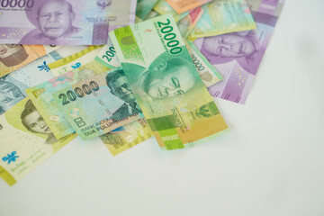 stack of various Indonesian banknotes with negative space, from one thousand rupiah to twenty thousand rupiah. Suitable for background, finance, banking, cash, savings.