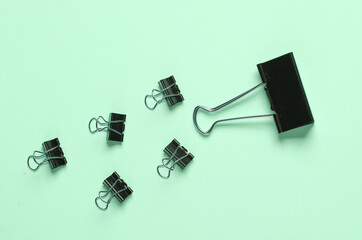 Black binder paper clips on a blue background. Business concept