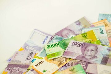 stack of various Indonesian banknotes with negative space, from one thousand rupiah to twenty thousand rupiah. Suitable for background, finance, banking, cash, savings.