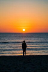 Fototapeta premium arafed man standing on the beach watching the sun set