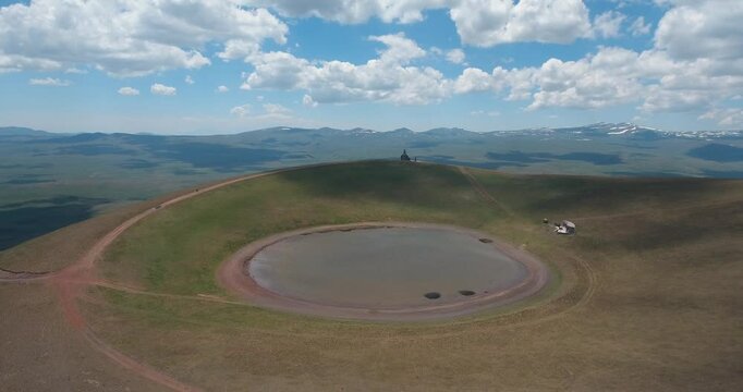 Drone footage of Mount Armaghan with a water pond on a sunny day