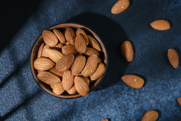 Top view of almonds in wooden bowl healthy food concept..