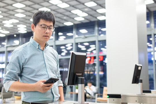 An Asian business man passes through the access control turnstile of the office building by facial recognition