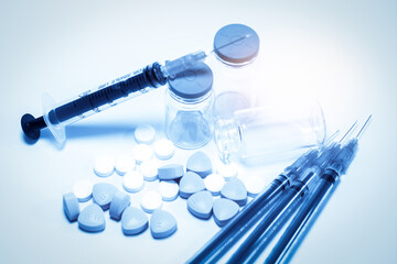Medical Supplies with Syringes and Pills on a Light Background