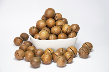 Macadamia nuts in white cup on white background