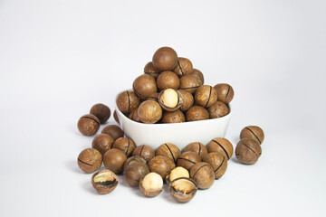 Macadamia nuts in white cup on white background