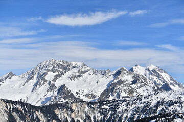 Obraz premium French alps on a sunny day under the clouds by winter covered with snow