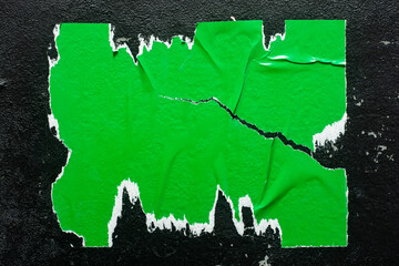 Torn green poster on black background.