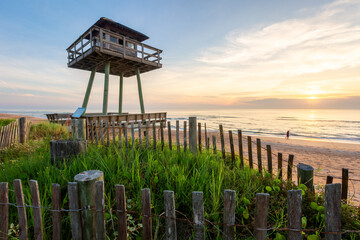 World War 2 submarine watchtower on beach with light breaking through clouds 