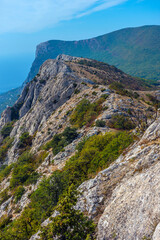Mountain range in Crimea with picturesque cliffs covered with bushes and low-growing trees. 