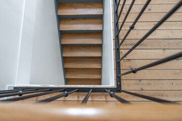 Escalier en parquet moderne avec garde-corps en métal dans un appartement rénové au style...