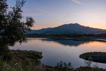 Mountains reflecting in a lake at sunset with purple sky