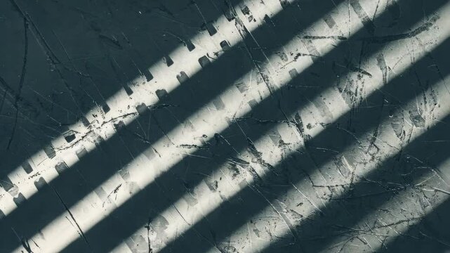 Dynamic shadows cast by window blinds creating linear patterns on textured wall surface adding contrast and depth