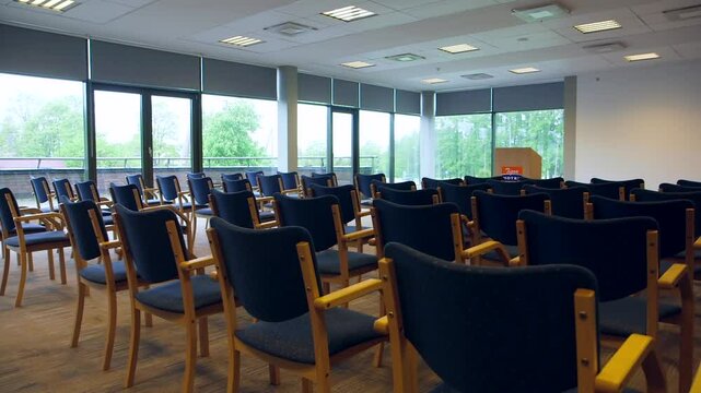 Empty, Simple Conference Room with Speakers Tribune and Classic Wooden Chairs. Conference Hall, Room, or Meeting Room is a Room Provided for Singular Events Such as Business Conferences and Meetings.