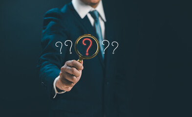 Question mark and problem analysis concept ,Businessman holding magnifying glass with question mark to show how to do cause analysis to find the answer that occurs during business process