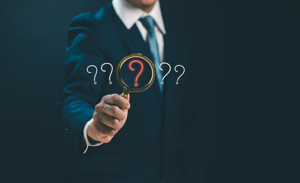Question mark and problem analysis concept ,Businessman holding magnifying glass with question mark to show how to do cause analysis to find the answer that occurs during business process
