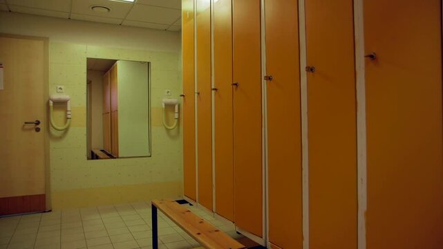 Orange Metal Lockers in the Changing Room. School, Sports Complex or Elsewhere. Changing Room, Locker Room or Changeroom is a Room or Area Designated for Changing One's Clothes.