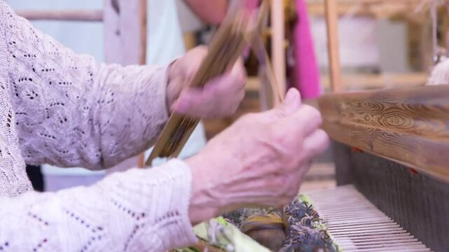 An Old Woman With Large Looms Weaves a Colorful, Decorative Tapestry or Carpet. Weaving is a Method of Textile Production in Which Two Sets of Yarns are Interlaced to Form a Fabric or Cloth.