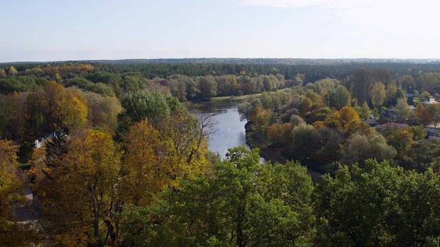 River flows through a rural village. In the background is a forest landscape. Valmiera is One of the Oldest Cities in Latvia, Having Been a Member of the Hanseatic League.