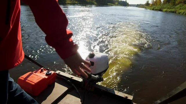 A man steers a boat with a motorboat engine while traveling down a river. A Motorboat or Powerboat is a Boat that is Exclusively Powered by an Engine. Faster Examples May be Called Speedboats.