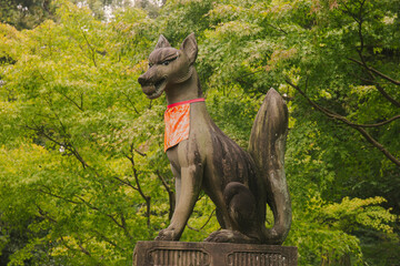 Kyoto, Japan – November 7, 2024: A fox statue at the entrance of Fushimi Inari Shrine. In Shinto...