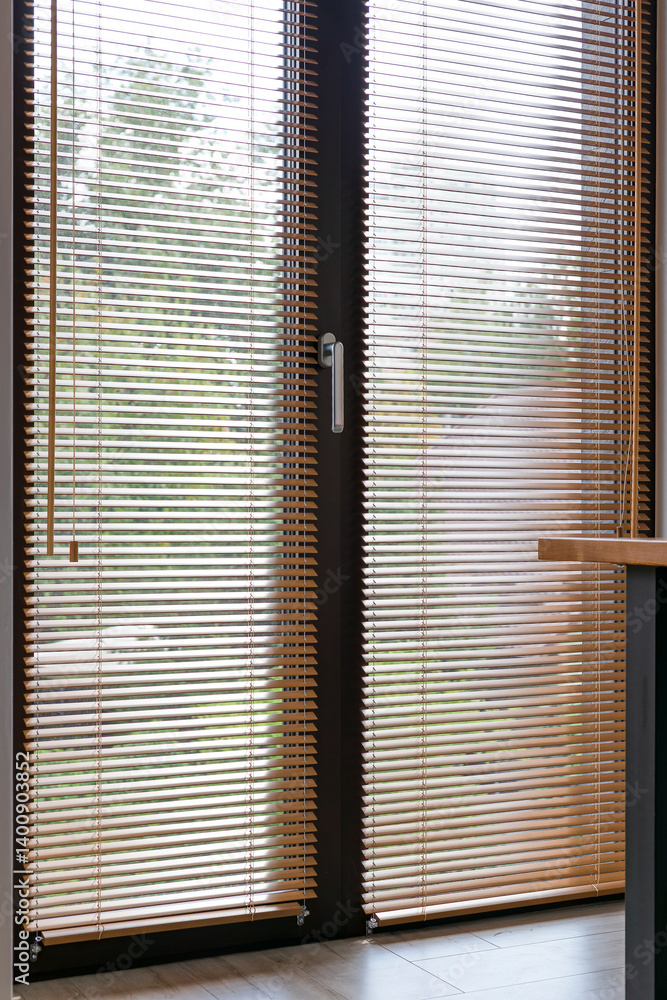 Poster full view of floor-to-ceiling glass doors covered with horizontal wooden blinds. the blinds on windo