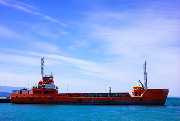 Empty cargo ship anchored on calm blue sea. Big ship and seascape view. Goods transportation by...