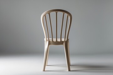 Minimalist light-colored chair positioned against a neutral backdrop, emphasizing simplicity and elegance.